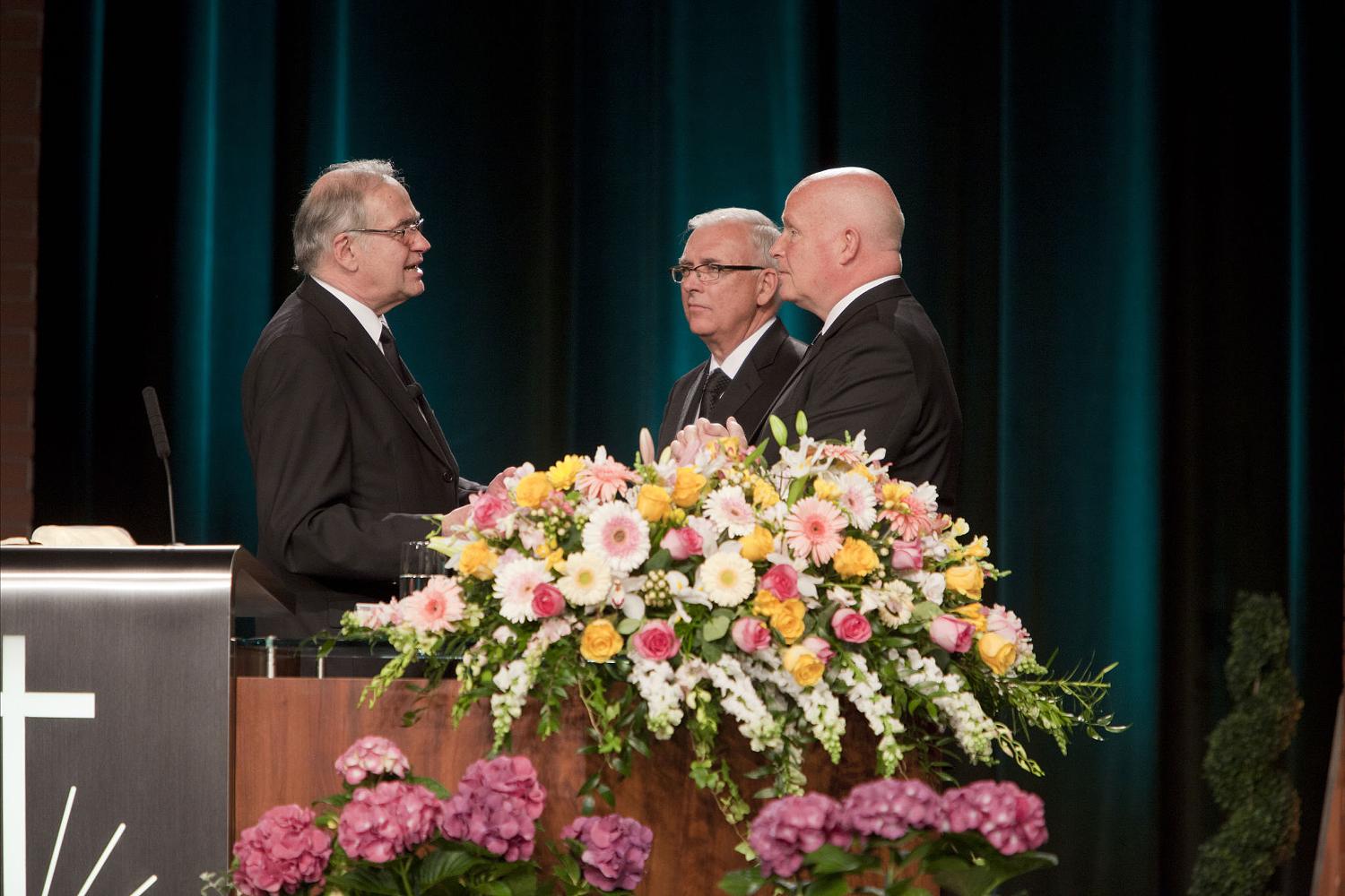 Apostel Hammer tritt in den Ruhestand (ganz rechts), Apostle Buehner empfängt sein neues Amt (Mitte, Fotos: NAC USA)